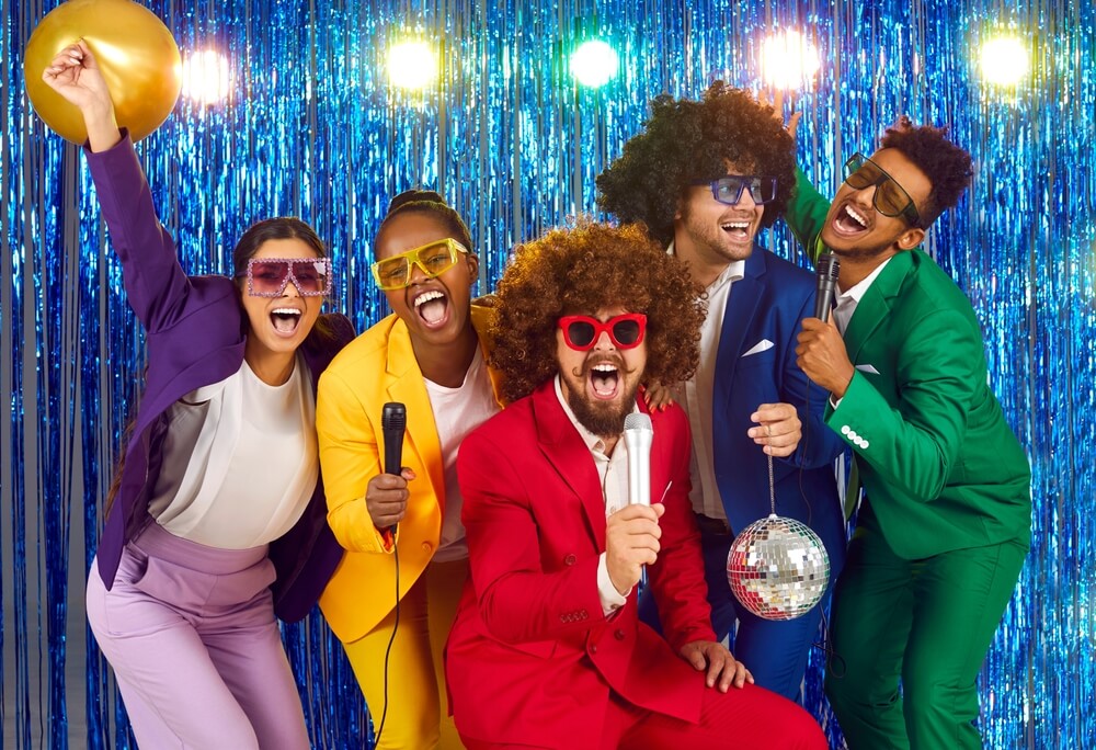 A group of people singing at the karaoke party.