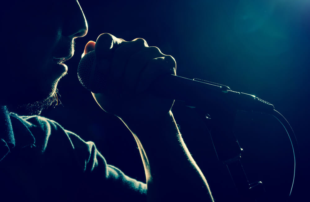 Closeup of a singer hand holding the microphone and singing.