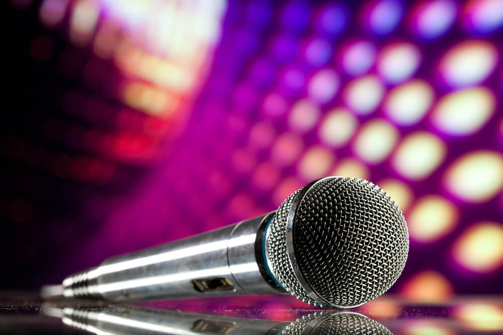 A microphone against purple disco background.