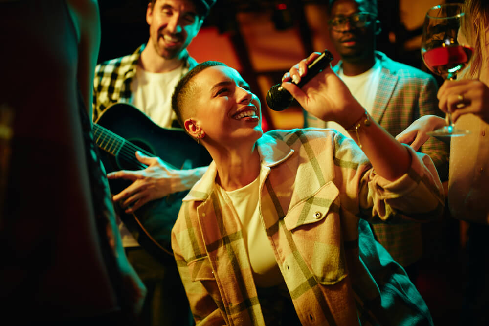 A woman holding microphone and singing while partying with her friends.