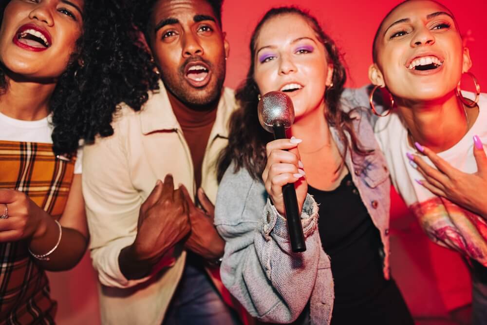 Vibrant friends singing together on karaoke night.