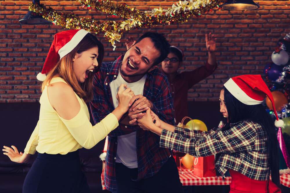 A girl with a microphone at the karaoke Christmas party.