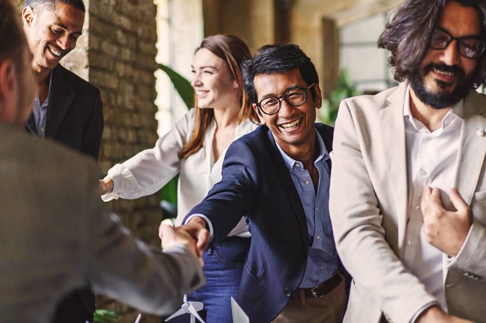 Group of professionals celebrating with a handshake at a corporate event.