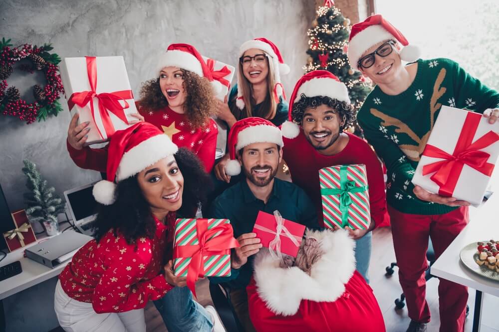 Portrait of company office workers holding presents.