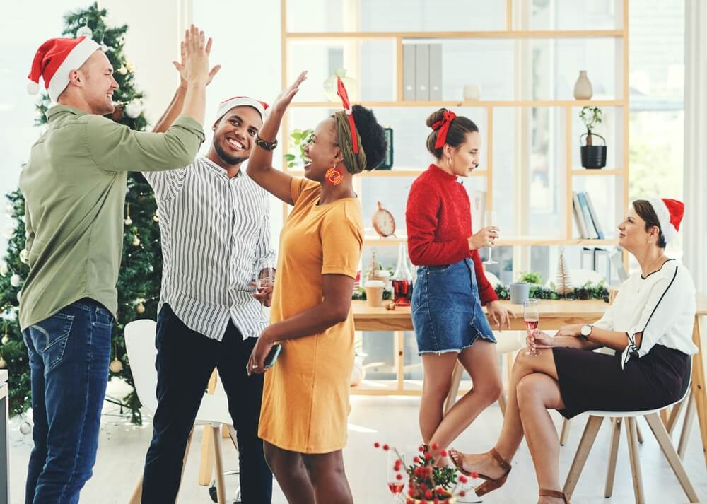 Business people having a Christmas party in their office together during the festive season.