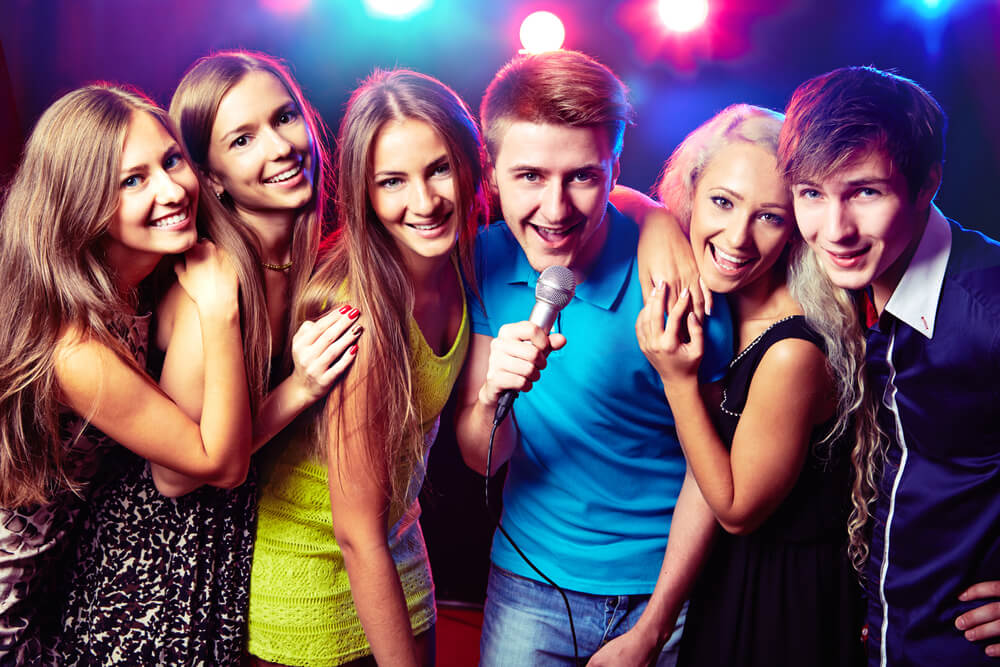 Young people singing at the karaoke birthday party.