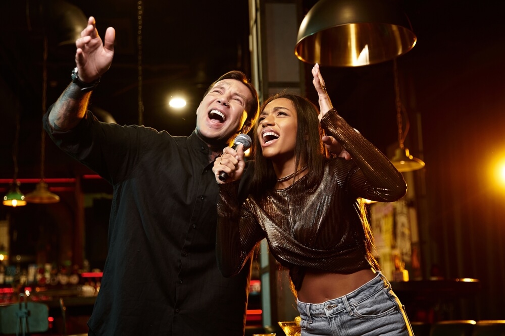 Young couple sharing laughter and music on a fun karaoke date night.