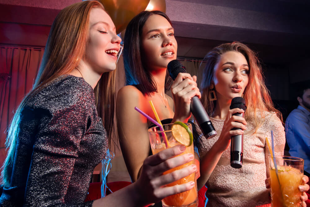 Group of girls having fun together at the karaoke birthday party.