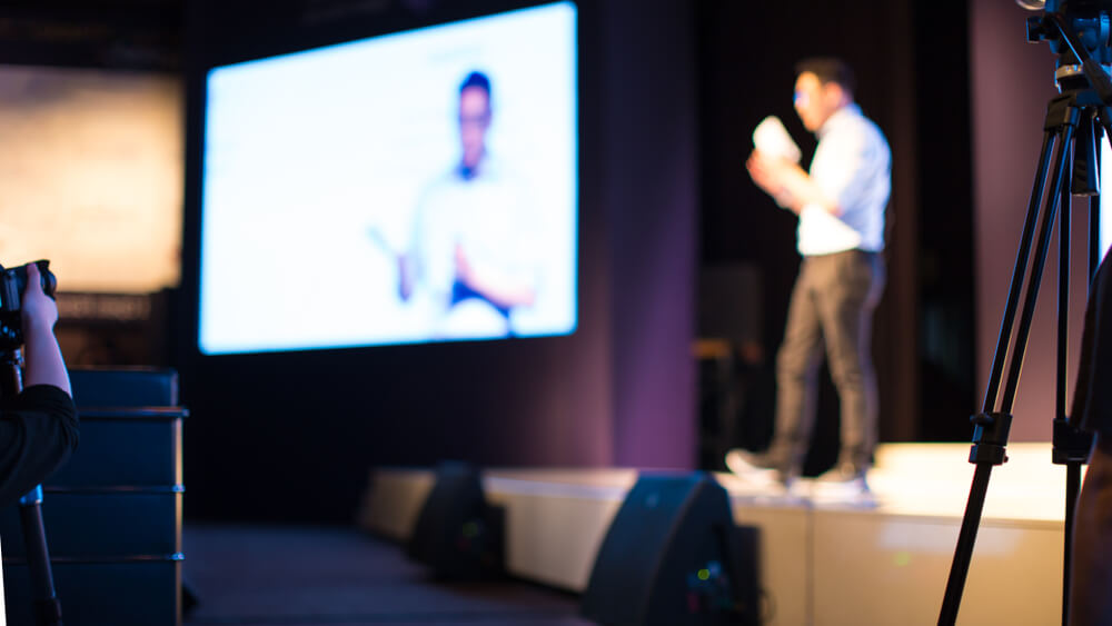 A speaker giving speech in conference hall auditorium. 