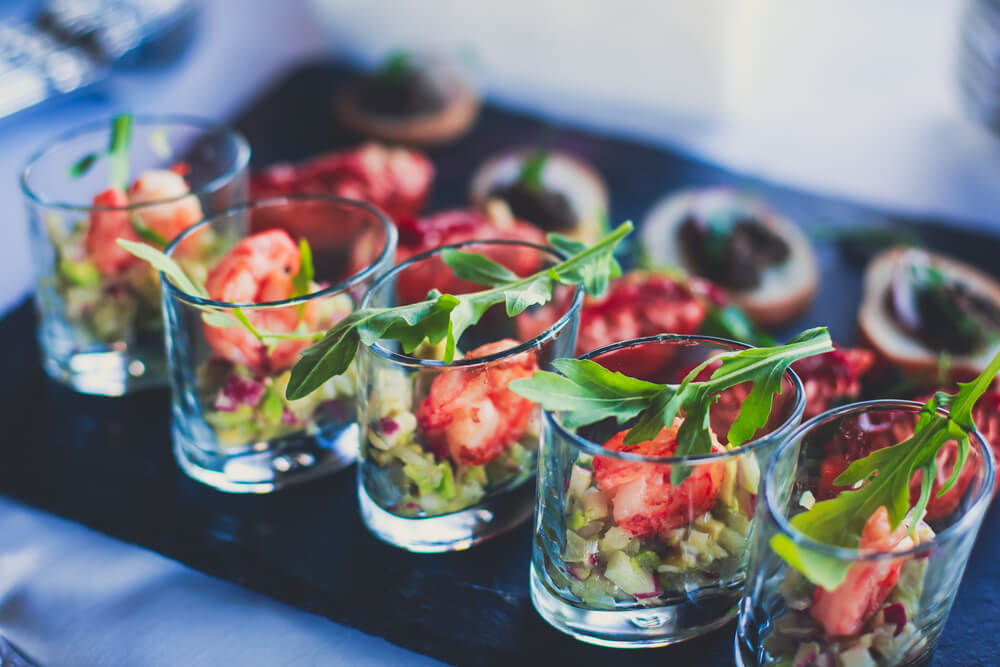 Beautifully decorated catering banquet table with different food snacks and appetizers on corporate party event.