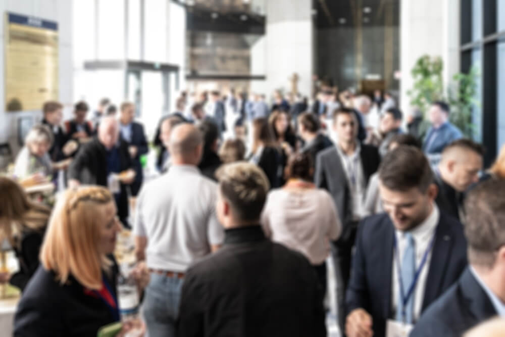 Blurred photo of business people socializing during banquet lunch break break at business event.