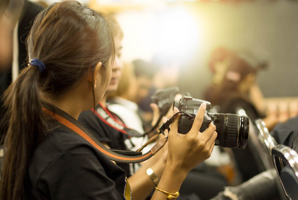 A woman holding camera at the corporate event.